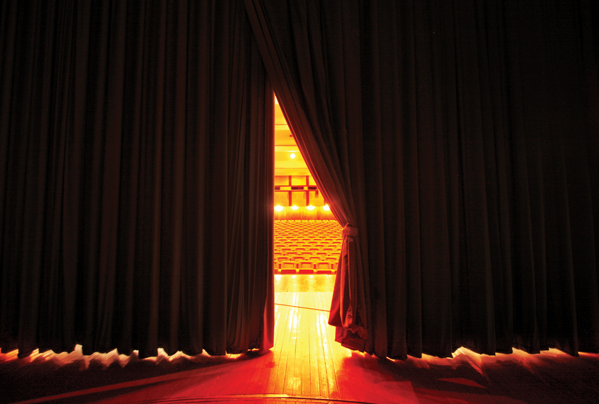 Curtain sliding open on stage, placing the star in the limelight.