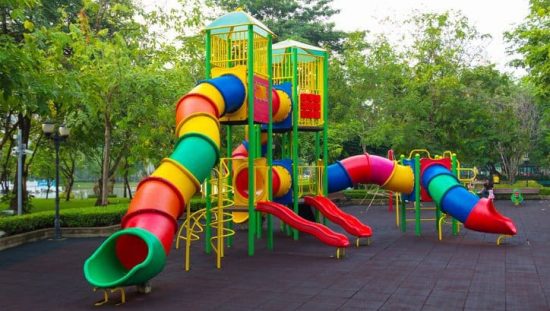 Colorful children's public playground kept safe with ASTM F1487-21.