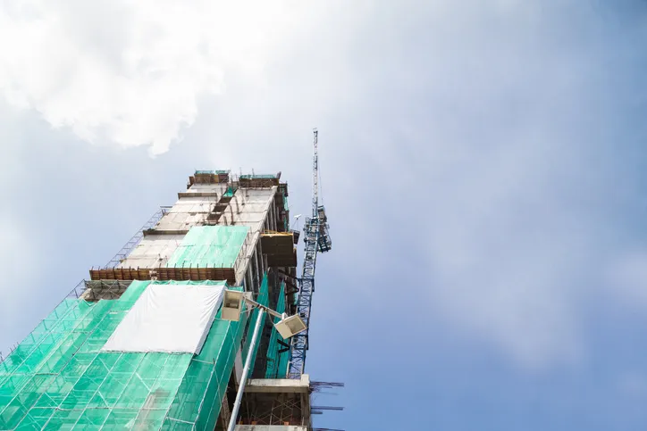 Building under construction with safety net around it that follows ANSI/ASSE A10