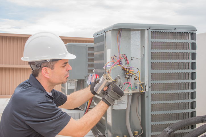 Electrician on the roof using NFPA 70E-2018 to fix some wires.