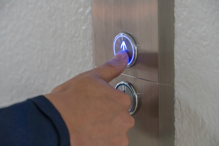 Pushing an elevator button up in accordance with ASME A17.1, or CSA B44, a binational standard.