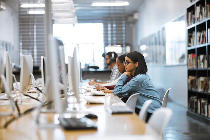 Girl working hard at school computer to manage her education