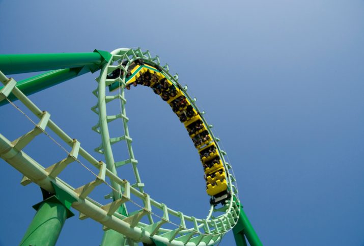Green roller coaster loop providing ASTM F2291-20 amusement ride patrons with safe thrills.