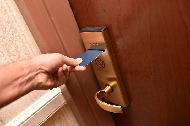 Sliding keycard into ANSI/BHMA A156.25-2018 electrified lock at hotel room.