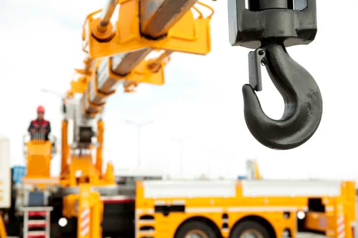 The black hook of an ASME B30.5-2021 mobile crane in foreground.