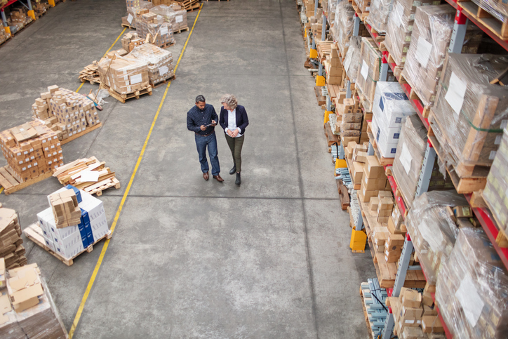 Two professionals in warehouse conducting an internal audit, not management review.
