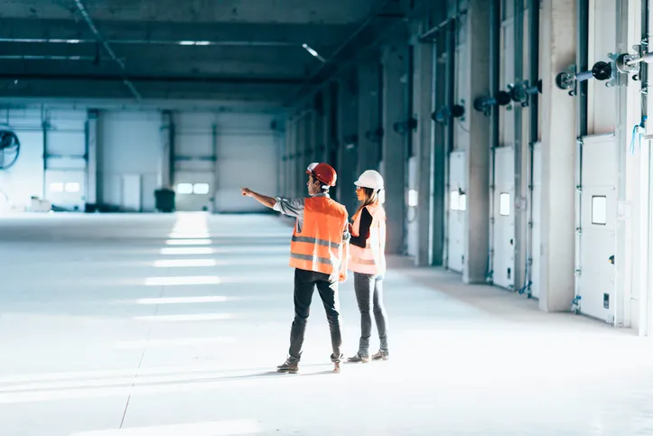Safety professionals examining open facility in conducting ISO 41001 facility management.