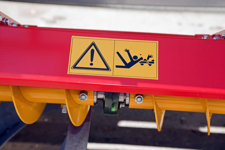 Caution warning on piece of machines that follows guidelines set by ANSI B11.19-2019