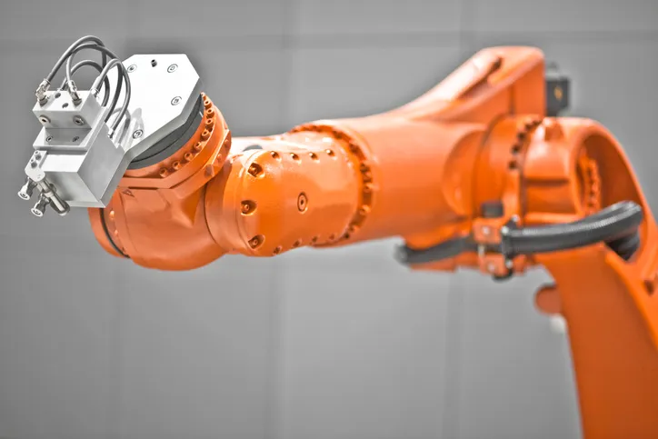 An orange ANSI B11.0-2020 robot arm not currently in operation.