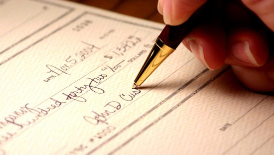 Signing a check with a gold pen to generate an ANSI X9.100-160-2-2020 MICR external processing code (EPC).