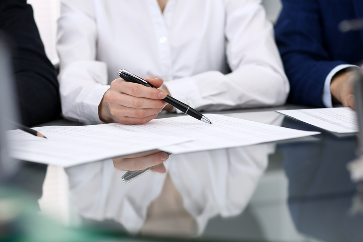 Tapping a pen on paper and finishing off the changes to ISO/IEC 17000:2020
