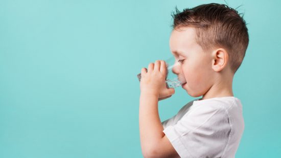 A boy hydrating with drinking water after being treated for NSF/ANSI 53-2020 health effect units.
