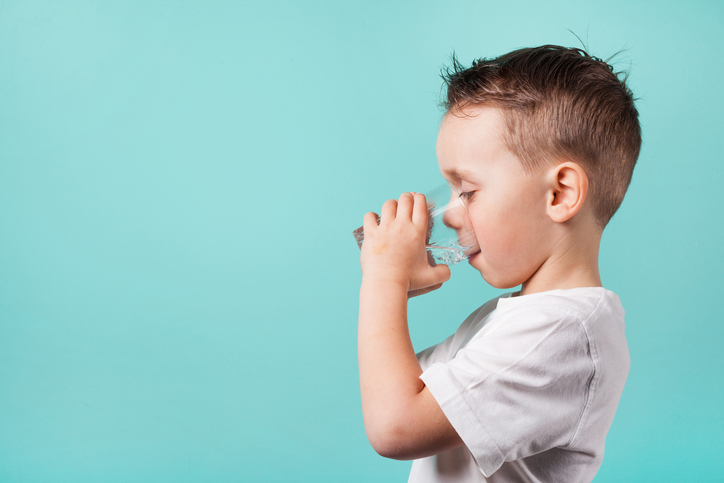 A boy hydrating with drinking water after being treated for NSF/ANSI 53-2020 health effect units.