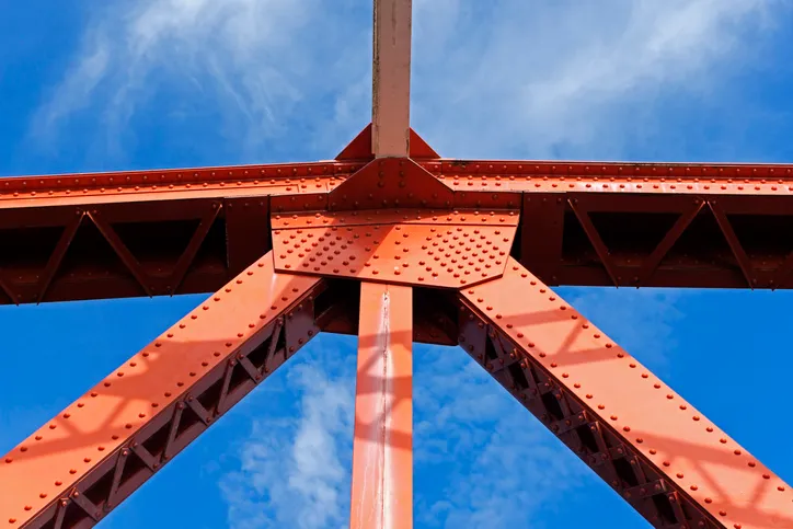 Red beams support bridge and are covered with ISO 12944 protective steel paint.