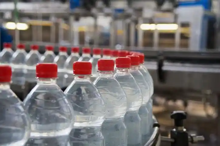 Bottling Plant Plastic water bottles looping through factory conveyor belt marked to ISO 11469:2016