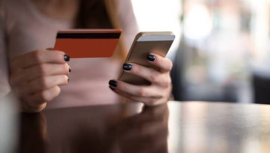 Woman entering her credit card info online thanks to ANSI/ASC X9 financial services industry standards.