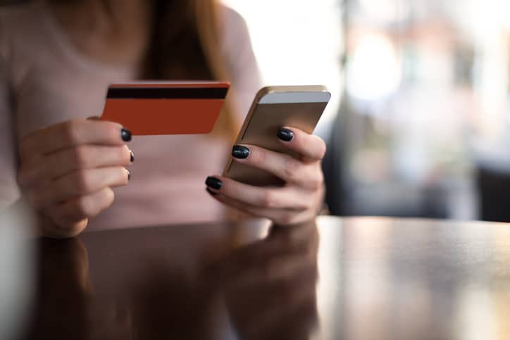 Financial Services Woman entering her credit card info online thanks to ANSI/ASC X9 financial services industry standards.