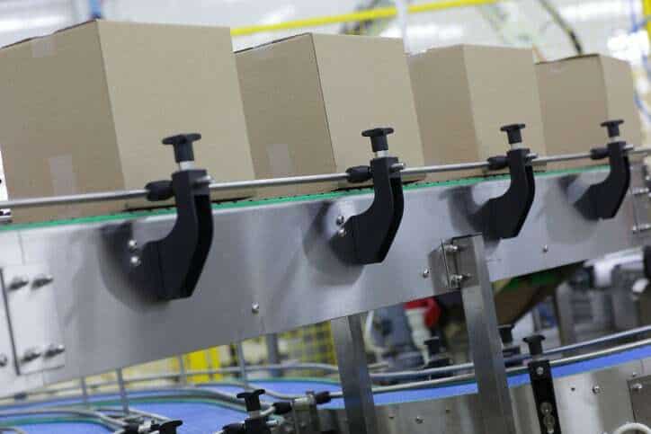 Packaging Boxes sliding down conveyor adhering to ANSI/PMMI B155.1-2016.