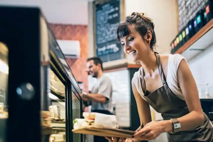 Restaurant Woman working at a deli, making quality sandwiches and knowing what to do thanks to ISO 9001:2015 for Small Enterprises.