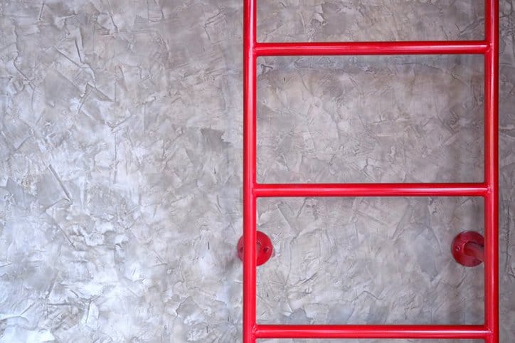Ladder A bright red ladder in an industrial warehouse highlights the importance of safety ladders.
