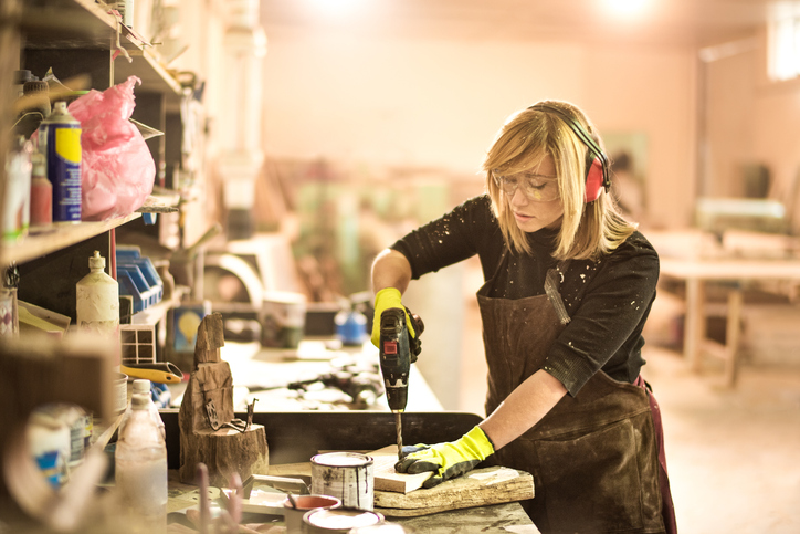Wearing Hearing Protection Worker using a drill with proper protection like ear protection that's specified in ANSI/ASA S12.6.