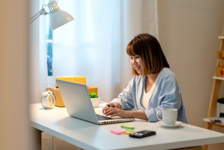 Woman happy yet inquisitive on laptop while going through ANAB live online management systems training.
