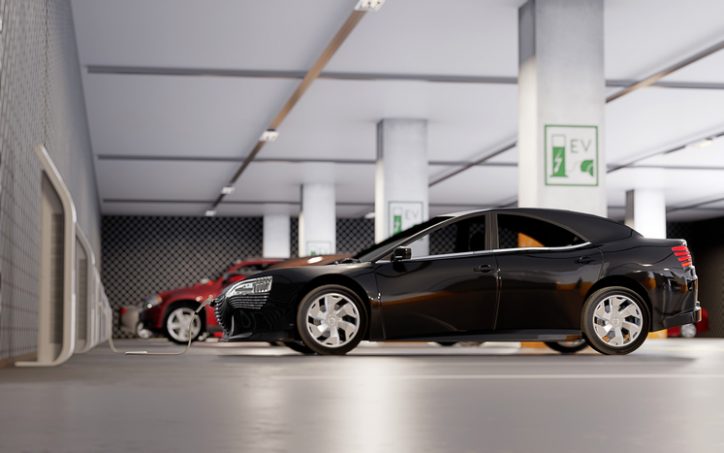 Electric vehicles charging to AC charging system infrastructure standards in parking garage.