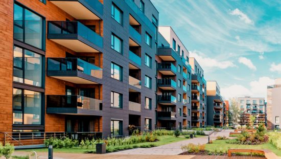 A multifamily building with verdant greenery assured to safety with ANSI/AARST MAMF-2017 radon measurements.