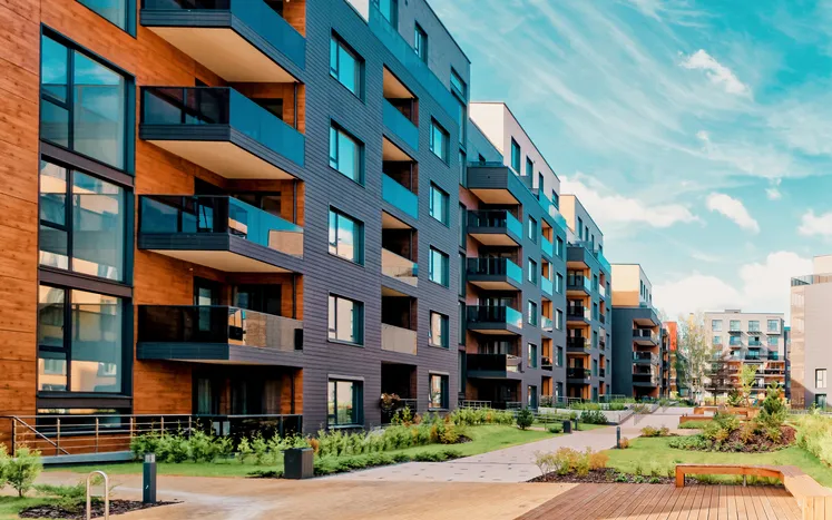 Apartment Building A multifamily building with verdant greenery assured to safety with ANSI/AARST MAMF-2017 radon measurements.