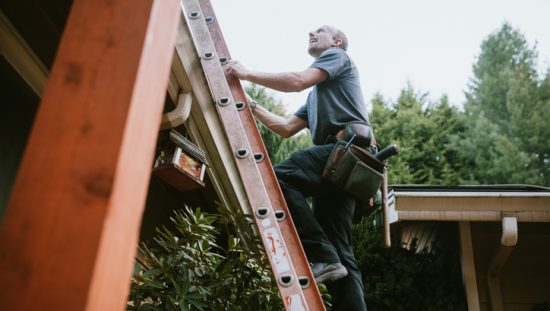 Man climbing ladder with three points of contact following safe inspection and environmental considerations.