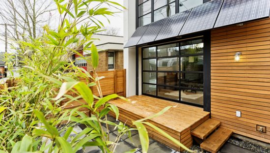 Wood home with greenery adhering to best International Energy Conservation Code (IECC) requirements.