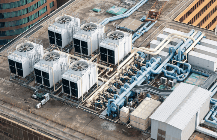 White mechanical building systems with spinning fans on HVAC systems safely following the 2021 International Mechanical Code (IMC).