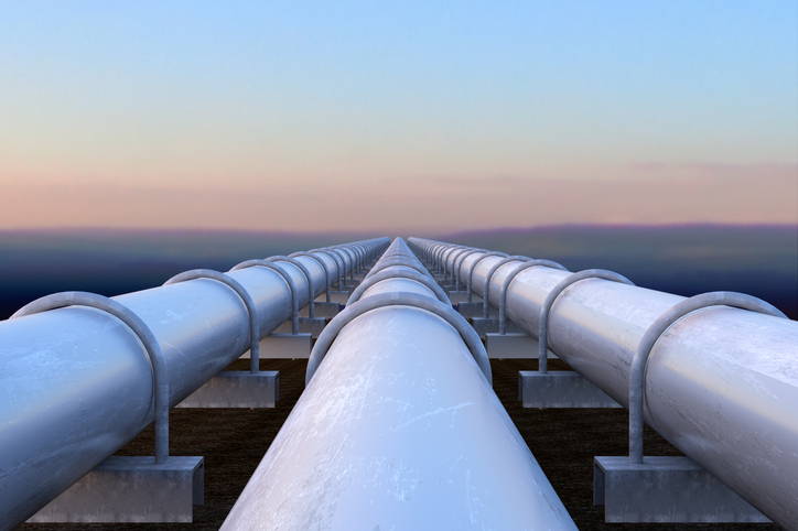 Pipeline Three white pipelines transporting gas out past the ocean.