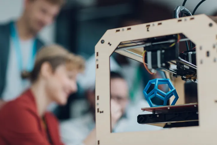 Additive Manufacturing File Format (AMF) Group in background formatting ISO/ASTM 52915:2020 additive manufacturing file format (AMF) to print blue hexagon.