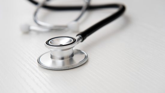 Stethoscope on wood adhering to ISO 15223-1:2021 for symbols on medical device labels.