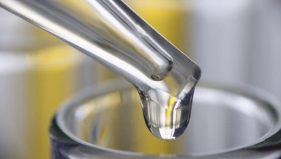 Liquid dripping from pipette as worker tests in standalone sampling organization laboratory.